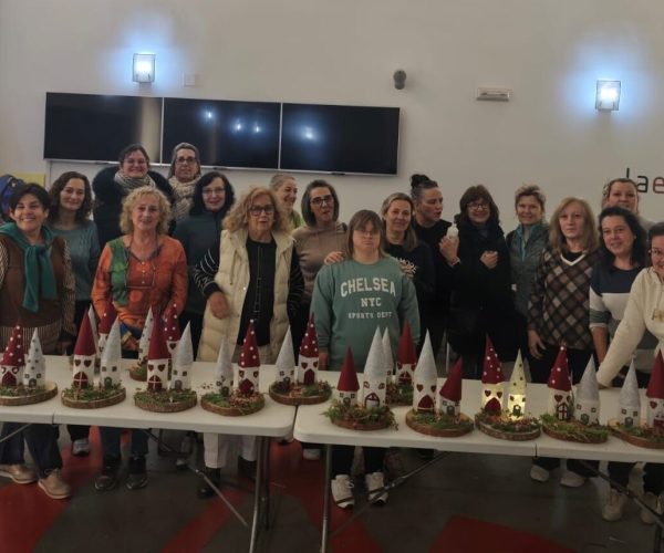 Grupo de personas posando con manualidades navideñas.
