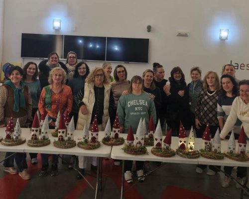 Grupo de personas posando con manualidades navideñas.