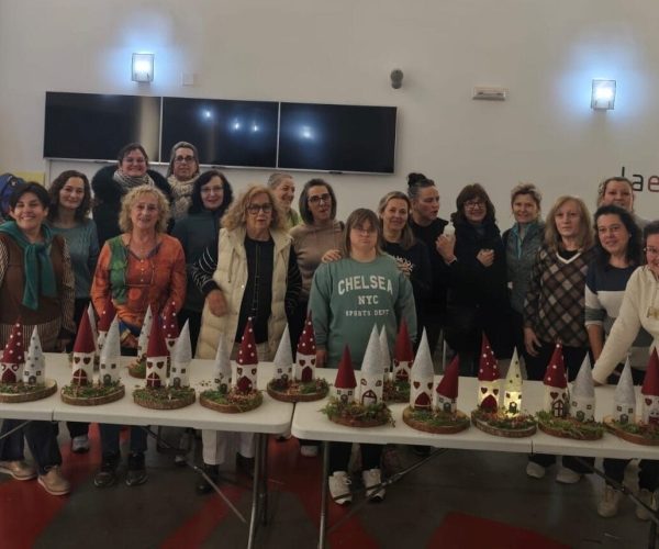 Grupo de personas posando con manualidades navideñas.